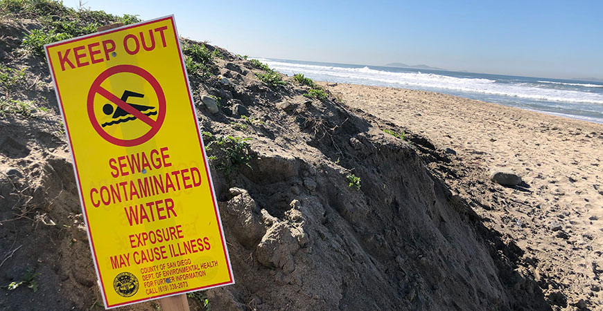 A sign on a southern California beach indicates it is unsafe to swim because of human-caused contamination.