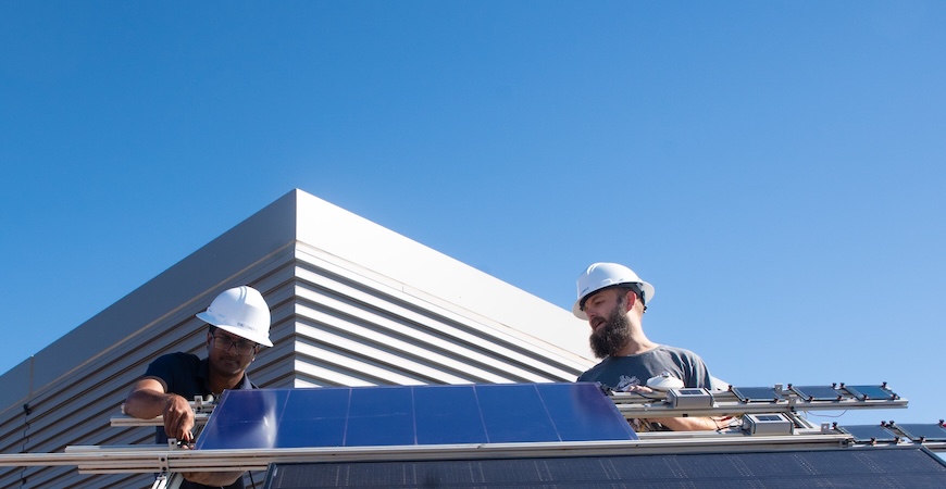 UC Merced graduate student Shariful Islam and Sean Dunfield of Tandem PV install a solar panel atop the SE2 building on campus.