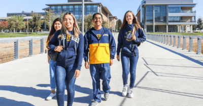 Student walking across a bridge on campus