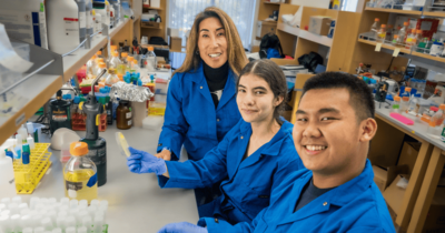 Two students and their professor in a UC Merced research lab.