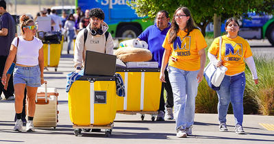 UC Merced students and parents using carts to move stuff into residence halls