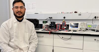 Postdoctoral researcher Dilawer Ali is seen sitting next to lab equipment at UC Merced.