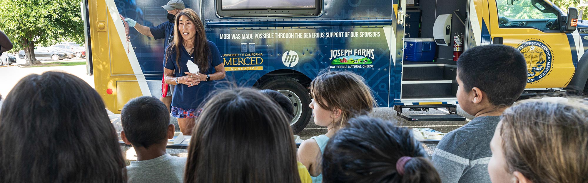 Community Engagement faculty member working with children in the community with the mobile maker vehicle
