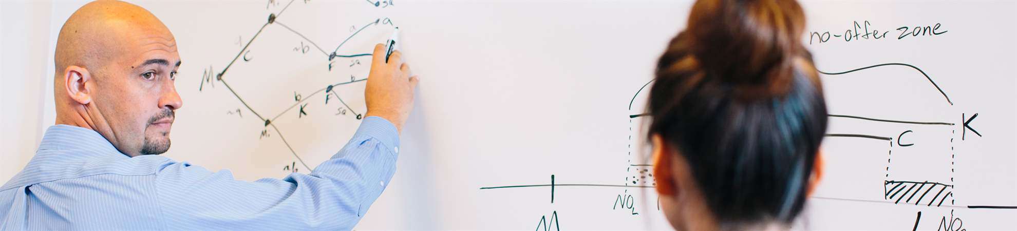 faculty member working with student using the whiteboard