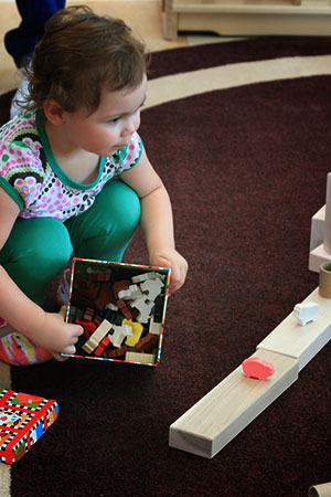 baby girl playing with blocks on the carpet floor