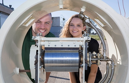 Graduate student Jonathan Ferry and undergraduate mechanical engineering major Jordyn Brinkley show off the solar-powered drum dryer.