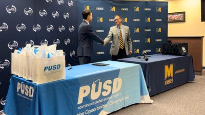 UC Merced Director of Admissions Dustin Noji and PUSD Superintendent Nate Nelson shake hands at a signing ceremony in the PUSD Board Room.