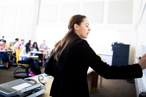 A woman writes on a whiteboard.